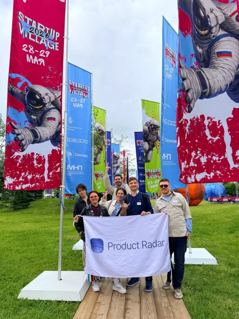 Участники команды Product Radar на фоне флагов на Startup Village 2026