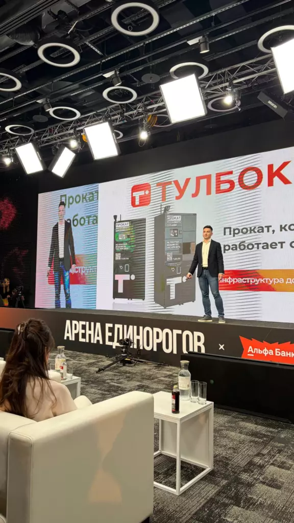 «Тулбокс» на сцене «Арены Единорогов» с презентацией: логотип Тулбокс, изображение умного бокса для аренды инструментов и слоган «Прокат, который работает». Съёмка из зала